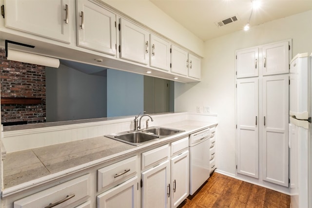 kitchen featuring dark wood-type flooring, white cabinetry, brick wall, white appliances, and sink