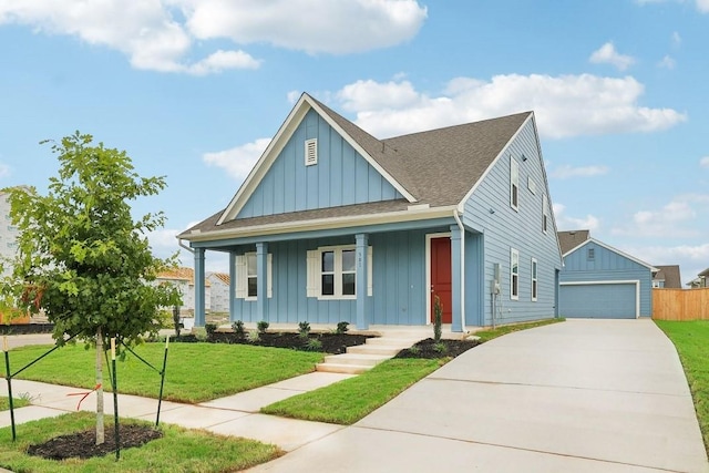 view of front of house featuring an outbuilding, a porch, a garage, and a front lawn