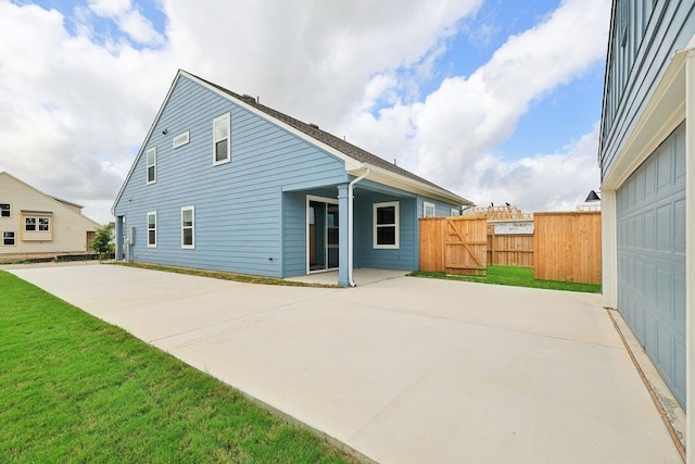 back of property with a yard and a patio