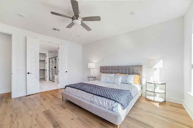 bedroom featuring ceiling fan, connected bathroom, and light hardwood / wood-style floors