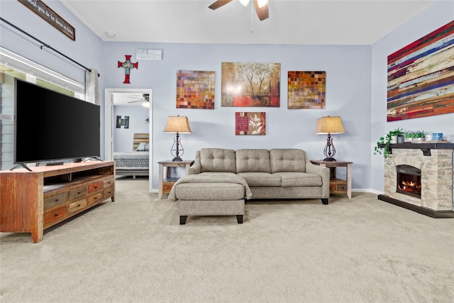 living room featuring carpet flooring, ceiling fan, and a fireplace