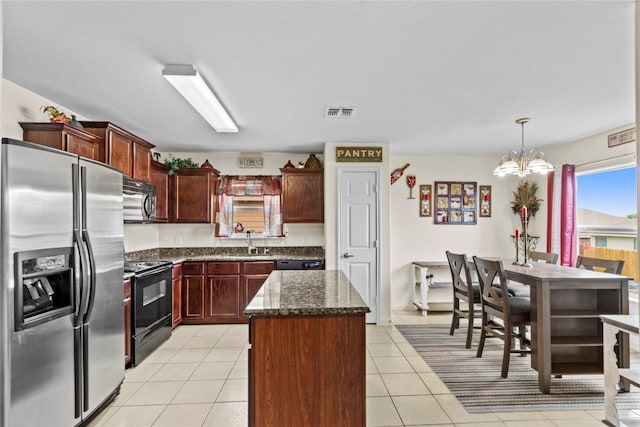 kitchen with light tile patterned floors, black range with electric cooktop, hanging light fixtures, a center island, and stainless steel fridge