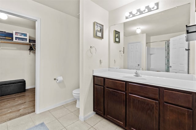 bathroom featuring a shower with shower curtain, tile patterned flooring, vanity, and toilet