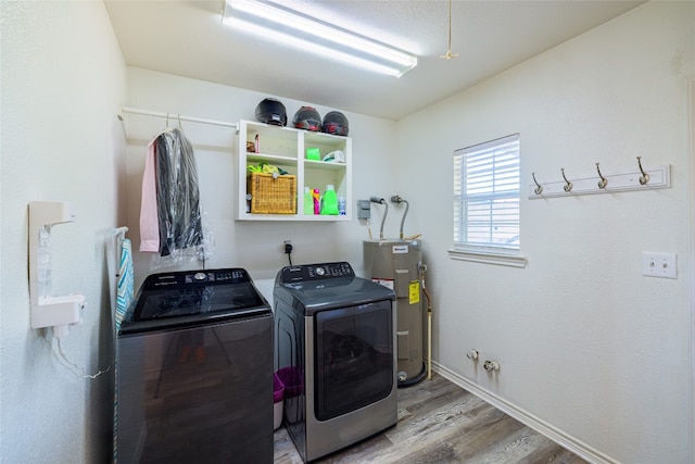 clothes washing area featuring water heater, hardwood / wood-style flooring, and independent washer and dryer