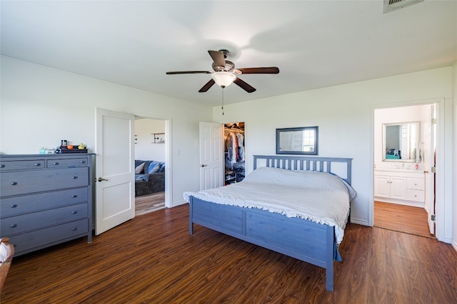 bedroom with connected bathroom, a spacious closet, ceiling fan, dark hardwood / wood-style floors, and a closet