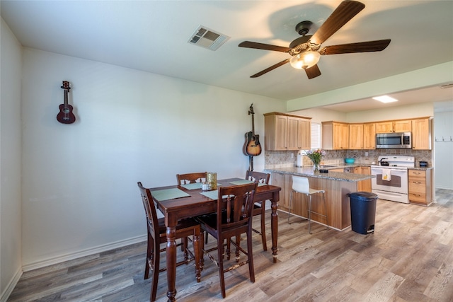 dining area with light hardwood / wood-style flooring and ceiling fan