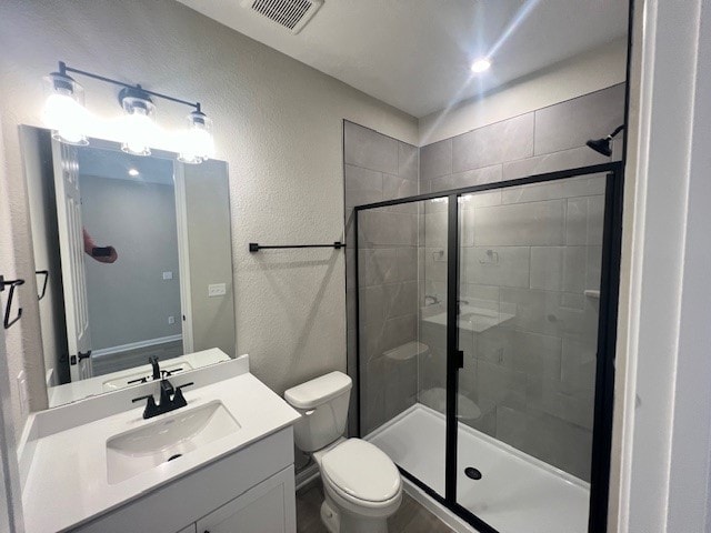 bathroom with an enclosed shower, toilet, and vanity