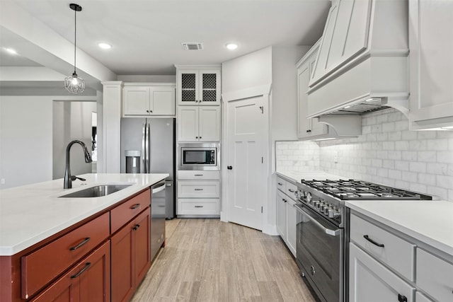 kitchen featuring white cabinets, sink, light hardwood / wood-style flooring, and stainless steel appliances