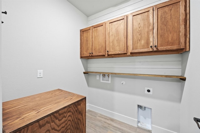 clothes washing area with hookup for an electric dryer, washer hookup, hookup for a gas dryer, light hardwood / wood-style floors, and cabinets