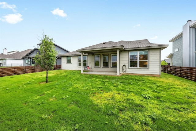 back of house with a yard and a patio