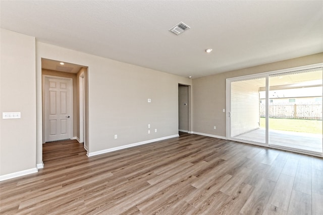 unfurnished room featuring a textured ceiling and light hardwood / wood-style floors