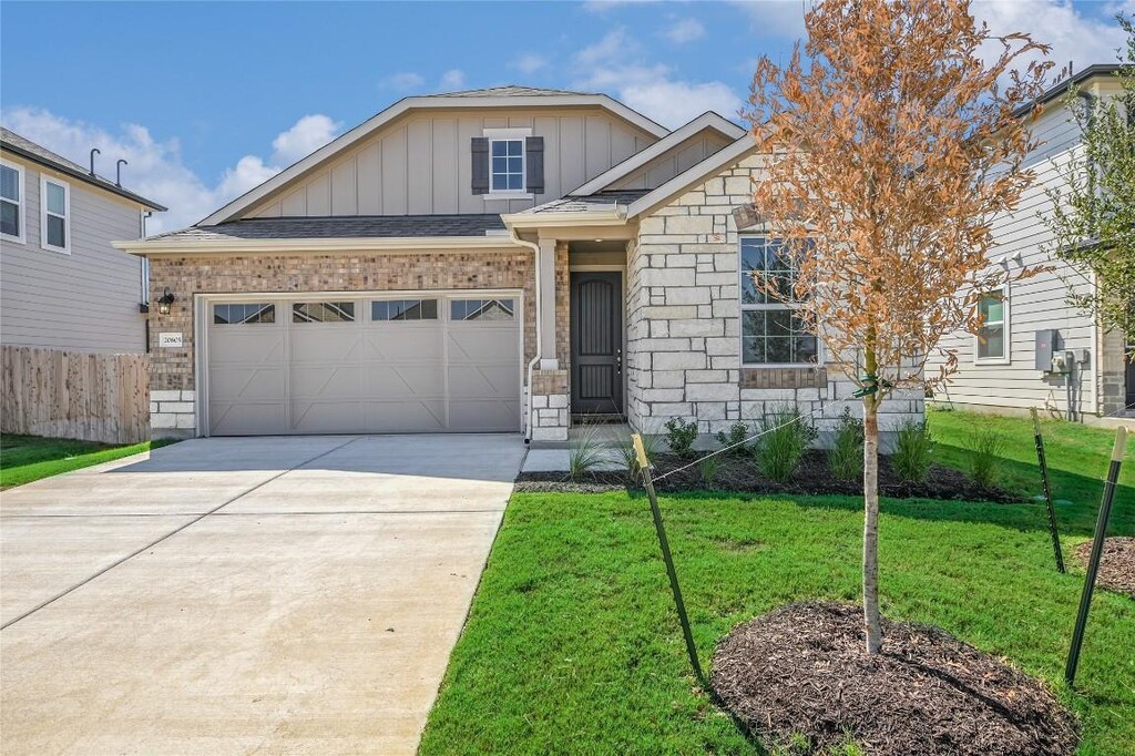 view of front of house with driveway, fence, board and batten siding, a front lawn, and a garage