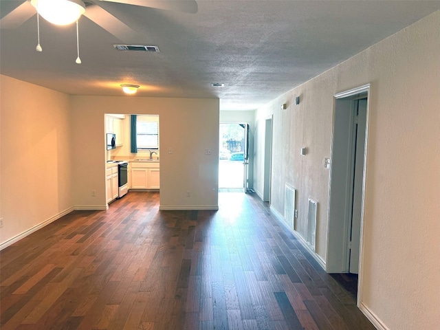 spare room featuring sink, dark wood-type flooring, and ceiling fan