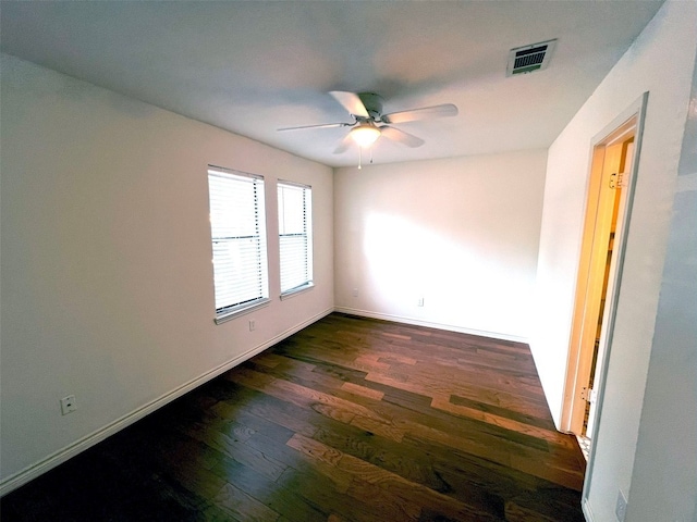 spare room featuring dark wood-type flooring and ceiling fan