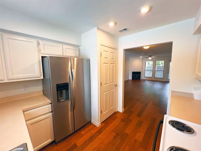 kitchen with range, stainless steel fridge with ice dispenser, white cabinetry, and dark hardwood / wood-style flooring