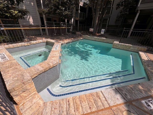 view of swimming pool with a hot tub