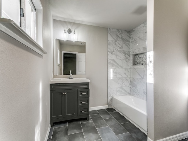 bathroom featuring tile flooring, tiled shower / bath, and vanity