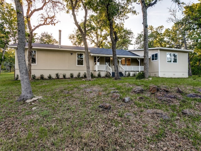 rear view of house with a porch and a lawn