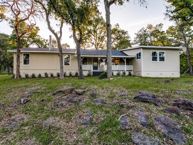 back of property featuring a porch and a lawn