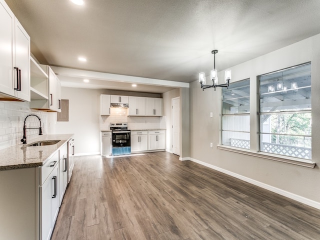 kitchen with sink, light stone counters, white cabinets, and dark hardwood / wood-style floors