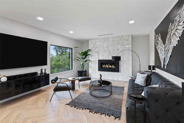 living room featuring a tile fireplace and light parquet floors