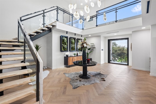 entryway featuring light parquet flooring and a high ceiling