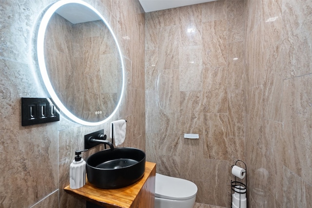 bathroom with sink, tile walls, and toilet