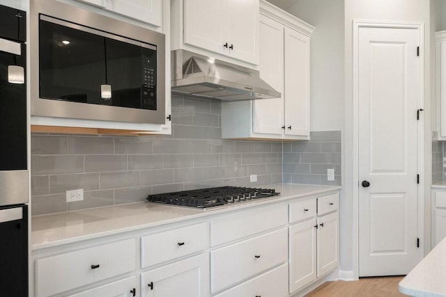 kitchen with white cabinetry, stainless steel gas cooktop, tasteful backsplash, wall oven, and built in microwave