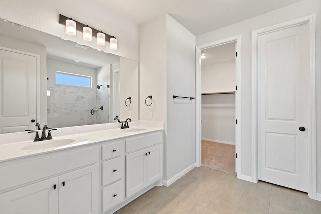 bathroom featuring tile patterned floors, walk in shower, and vanity