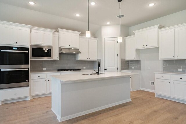 kitchen with sink, white cabinets, pendant lighting, and appliances with stainless steel finishes