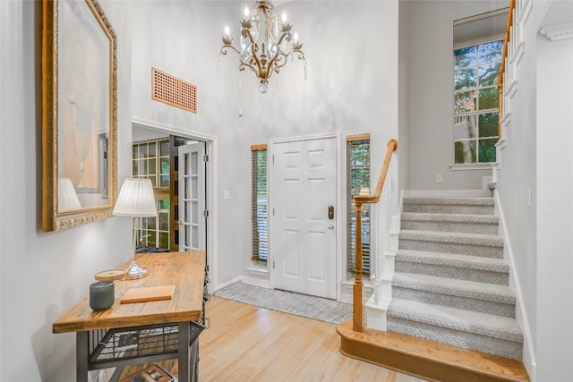 entrance foyer with a chandelier, a high ceiling, and light hardwood / wood-style flooring