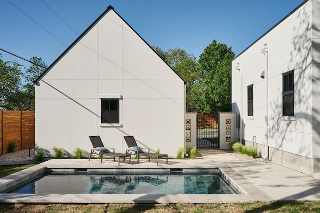 rear view of house with a patio area and a fenced in pool