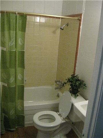 bathroom featuring shower / tub combo with curtain and toilet