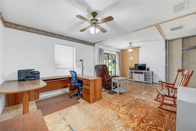 carpeted home office with a textured ceiling and ceiling fan