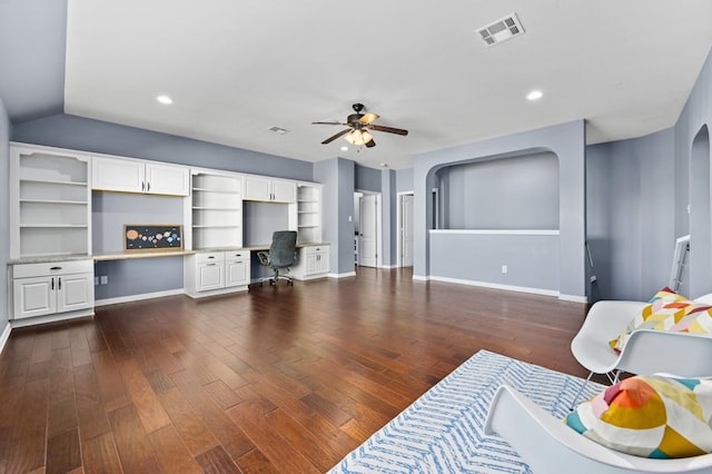 living room with dark wood-type flooring, built in desk, ceiling fan, and vaulted ceiling