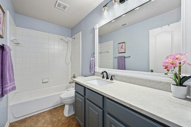 full bathroom featuring toilet, vanity, tile patterned floors, and tiled shower / bath