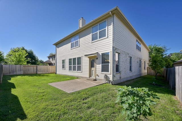 back of property with a yard and a patio area