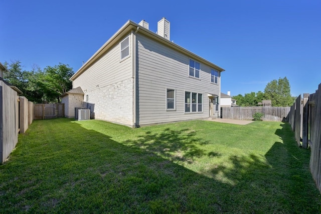 rear view of property featuring a patio, cooling unit, and a lawn