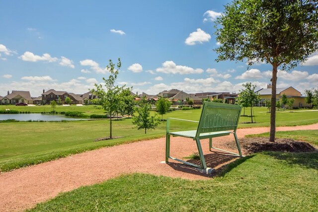 view of home's community with a lawn and a water view