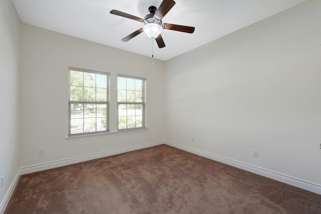 spare room with ceiling fan and dark carpet