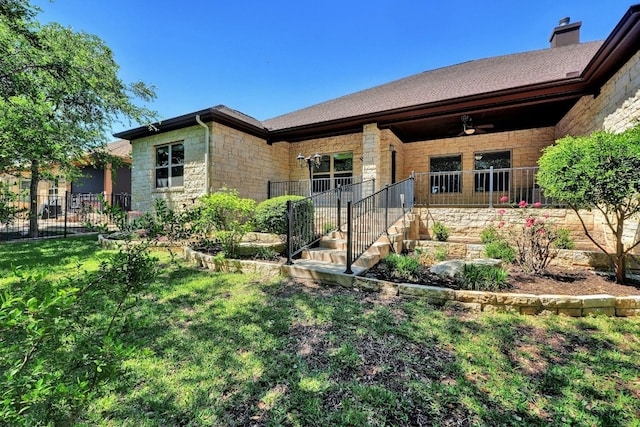 view of front of home featuring ceiling fan and a front yard