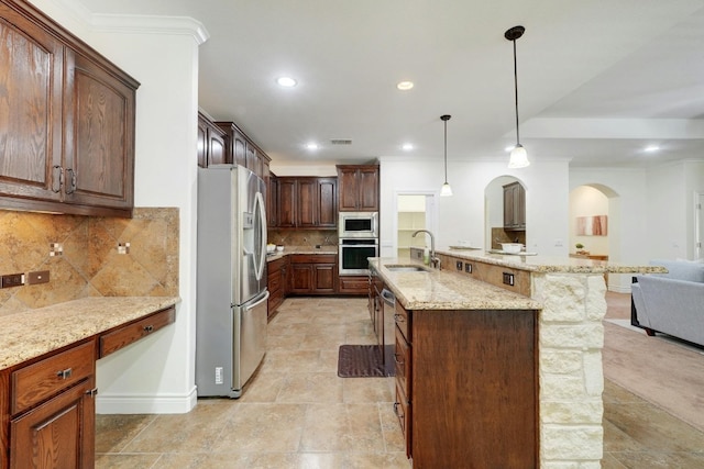 kitchen featuring a spacious island, sink, hanging light fixtures, tasteful backsplash, and stainless steel appliances