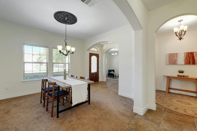 carpeted dining area with ornamental molding and an inviting chandelier