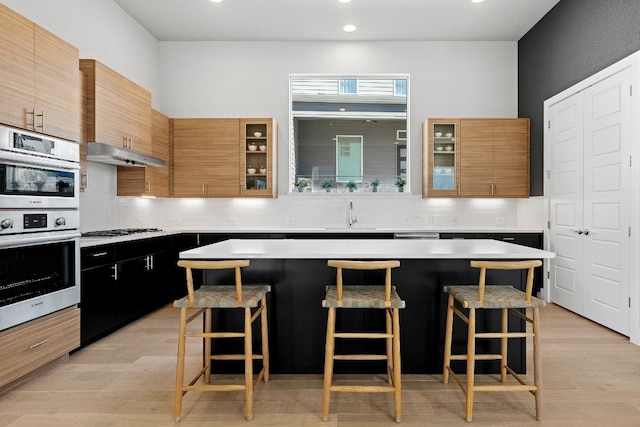 kitchen featuring backsplash, a kitchen breakfast bar, a center island, and appliances with stainless steel finishes