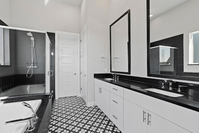 bathroom featuring oversized vanity, a washtub, double sink, and tile flooring