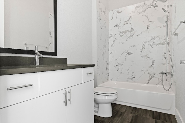 full bathroom featuring tiled shower / bath combo, vanity, and toilet