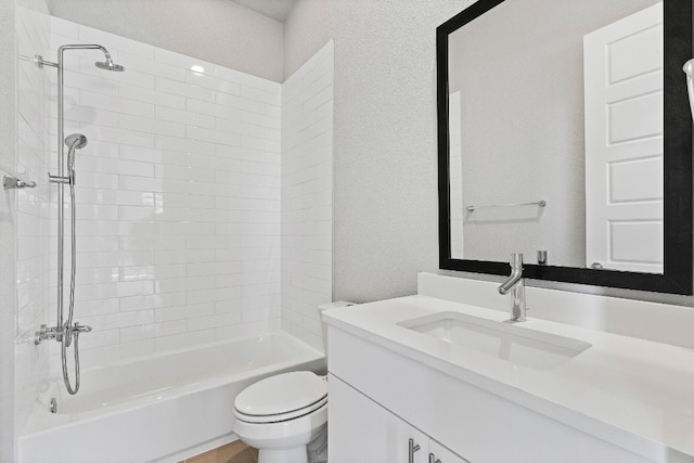 full bathroom featuring tiled shower / bath combo, toilet, and vanity