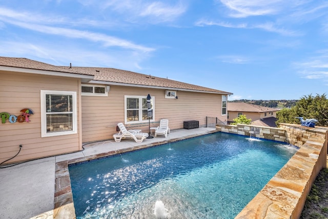 view of swimming pool with pool water feature and a patio area