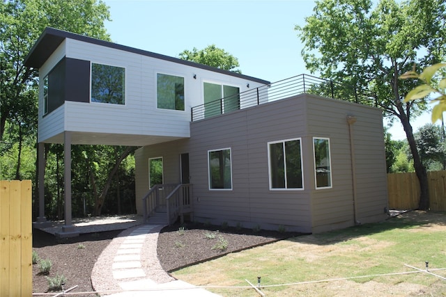 contemporary home featuring a front lawn and a balcony