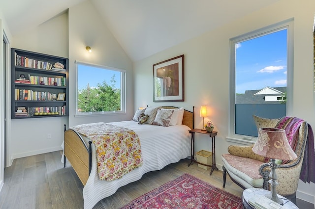 bedroom featuring vaulted ceiling, wood-type flooring, and multiple windows